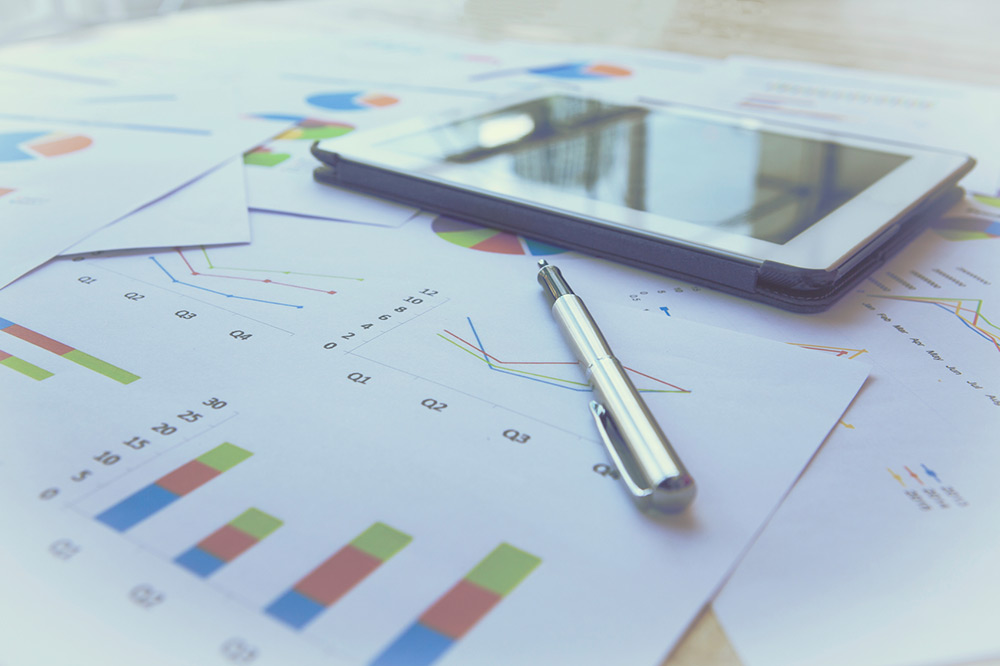 Marketing graphs, pen, and iPad